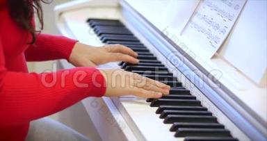 一名学生或专业钢琴家在一架漂亮的白色钢琴上演奏古典音乐，钢琴家的手